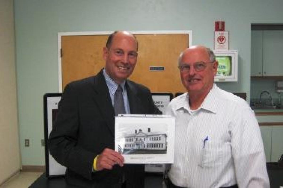Register Buckley with Bob Wood and a picture of the Bridgewater Academy Building.
