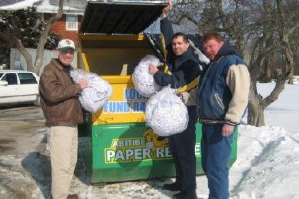 Register of Deeds John Buckley, Registry Director of Operations John Zigouras and Building Supervisor Jim O'Meara putting first bags of shreded paper in the recycling bin.